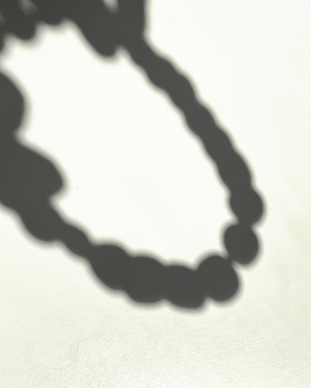 Reflejo minimalista del collar JASS capturado en un instante de luz.